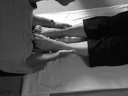 Mann hält zart die Füsse seiner Frau